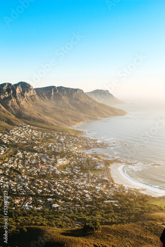 View of the 12 apostles and Camps Bay seen from the peak of Lions Head lookout point at sunset.