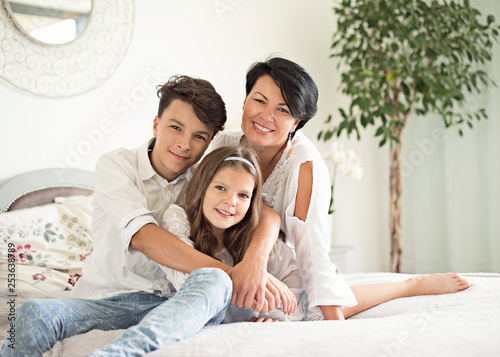  Mama i dzieci, syn i córka razem, dzień matki, happy family with two children lying down and looking at camera - portrait 