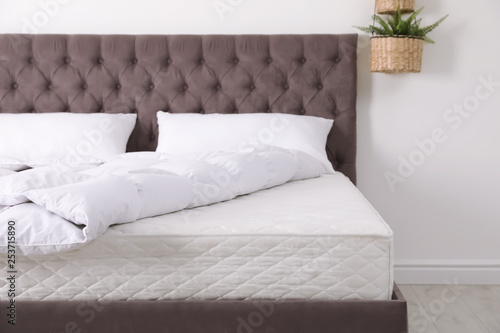 Comfortable bed with new mattress in room. Healthy sleep