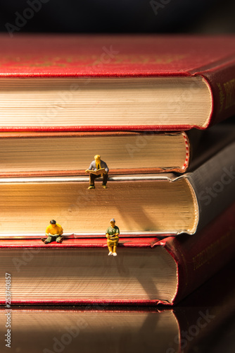 Little figures reading book on book