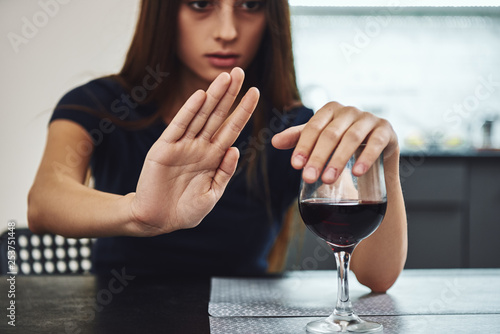 Recovery is something that you have to work on every single day and it’s something that doesn’t get a day off. Addicted woman refuses to drink a glass of red wine. Close up