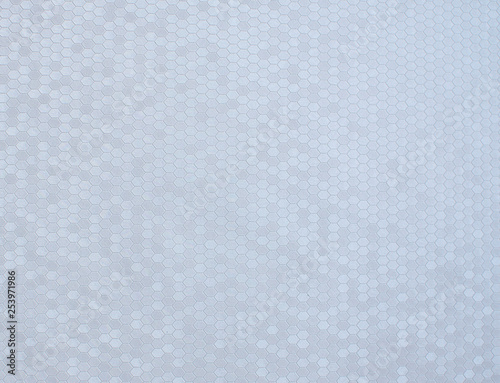 Texture of artificial radiant skin with honeycomb perforation. Abstract background, defocus.