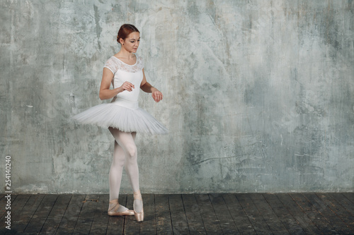 Ballerina female. Young beautiful woman ballet dancer, dressed in professional outfit, pointe shoes and white tutu.