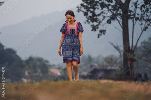 portrait of beautiful asian woman in dress north in lanna thai style with walking in nature in smile and relaxing emotional