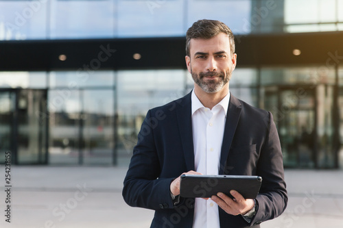 Empresario con tablet en distrito financiero