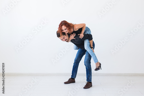 Friendship, people concept - young woman jumped on the man's back