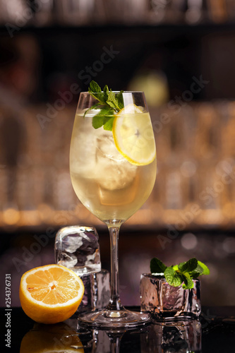 Hugo cocktail drink with ice cubes, mint and lemon