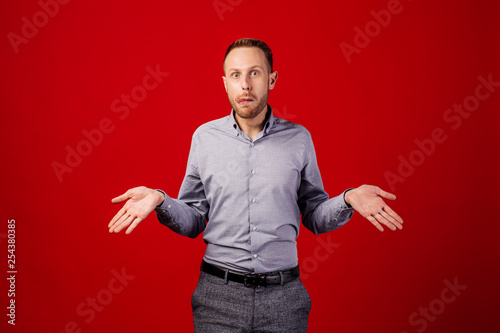 man with confused. emotions, facial expressions, feelings, body language, signs. image on a red studio background