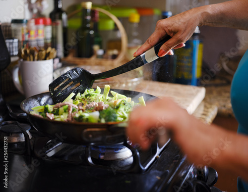 cooking beef and broccoli stir-fry in hot pain inside home kitchen