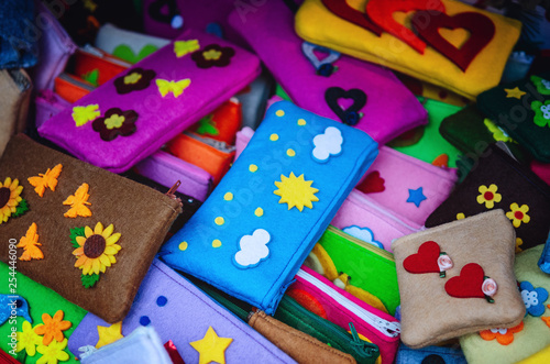 many felt handmade pencil cases for children's school, with flowers, clouds and heart shaped decorations 