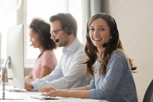 Happy businesswoman call center agent looking at camera at workplace