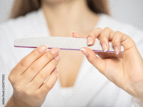 Woman gets manicure procedure in a spa salon. Beautiful female hands.