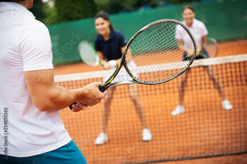 Group of healthy happy friends at the club playing tennis