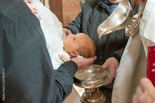 Baptism ceremony in Church. pour holy water on the head on a white blankets, baptism Christening the baby at the Orthodox church