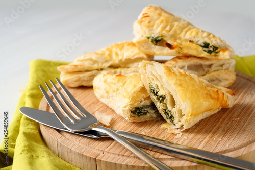 puff pastry filled with spinach and ricotta on a wooden kitchen board