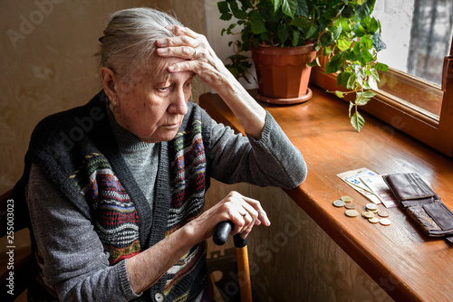 Portrait of an old woman counting money, euros. The concept of old age, poverty, austerity.