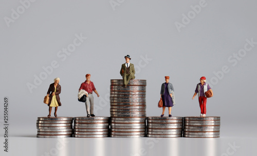 Social stratification concept. Miniature people with stack of coins.