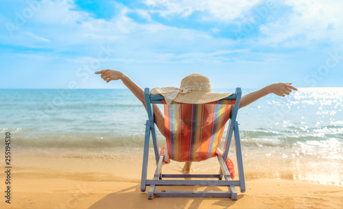 Summer beach vacation concept, Asia woman with hat relaxing and arm up on chair beach at Koh Mak, Trad, Thailand