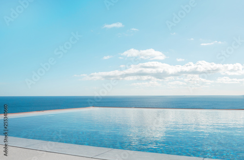 Luxury swimming pool in front of the sea. Swimming pool with beautiful sea and sky view.