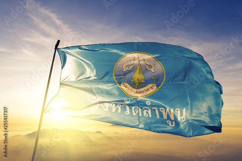 Lamphun province of Thailand flag waving on the top sunrise mist fog