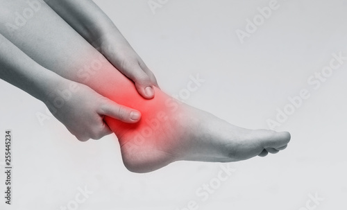 Woman suffering from pain in ankle closeup