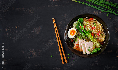 Miso Ramen Asian noodles with egg, pork and pak choi cabbage in bowl on dark background. Japanese cuisine. Top view. Flat lay