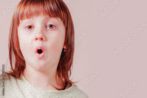 Humorous portrait of surprised little cute child girl with wide open eyes and open mouth. Emotions, gestures, body language concept.