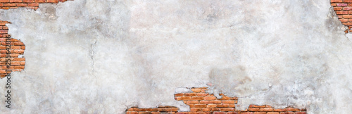 Damaged plaster on brick wall background. Brickwork under crumbling texture concrete surface