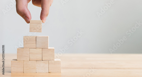 Hand arranging wood block stacking as step stair. Business concept for growth success process