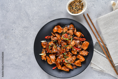spicy chicken in sweet and sour sauce with chili pepper. teriyaki chicken's with sesame seeds. Chinese cuisine, Thai cuisine. Japanese food, copy space, recipe background, food flat lay