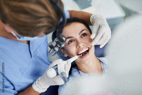 Charming young woman receiving dental treatment at clinic