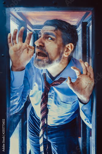 Businessman Inside of Glass Box. Concept of Captivity, No Freedom. Stressful Job, Pressure at Work. Lack of Space, Office Worker. Emotional Distress, Claustrophobia.