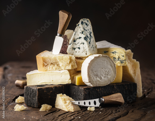 Assortment of different cheese types on wooden background. Cheese background.