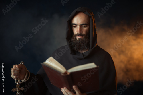 Medieval monk praying with book in church
