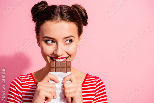 Close-up portrait of her she nice cute charming attractive glamorous cheerful sly cunning hungry girl in striped t-shirt biting tasting eating desirable favorite dessert isolated on pink background