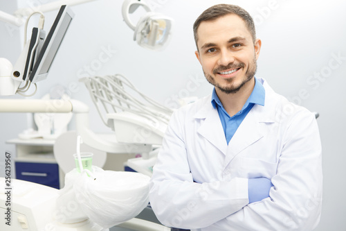 Handsome male professional dentist at his office