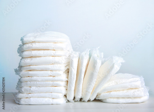 Stack of baby diapers on table.