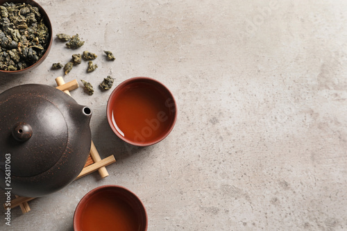 Flat lay composition with cups of Tie Guan Yin oolong tea and space for text on table