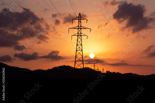 沈む太陽と送電線の鉄塔 夕焼け 空 美しい風景