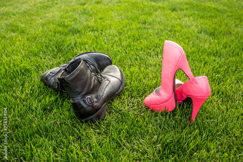 Man and woman shoes on green grass, spring is coming concept. Dating