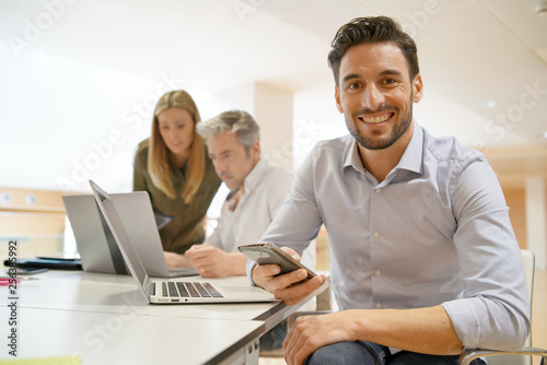 Startup team member smiling at camera in office