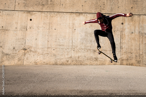 Man jumping and riding with a skateboard outdoors in a city