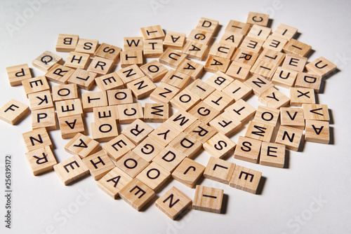 Alphabet letters on wooden scrabble pieces scattered