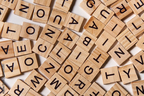 Alphabet letters on wooden scrabble pieces scattered