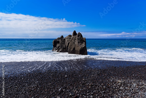 Panoramic view at the rock formation on a beach against blue sky