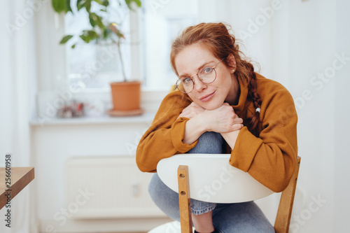 Thoughtful introvert young woman seated in a chair