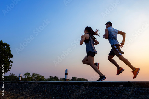 Running at sunrise couple exercising for marathon and workout .fitness, sport, people and lifestyle concept - Happy couples exercising with outdoor running