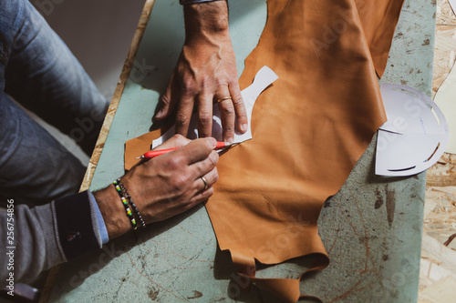 Shoe designer working with leather.