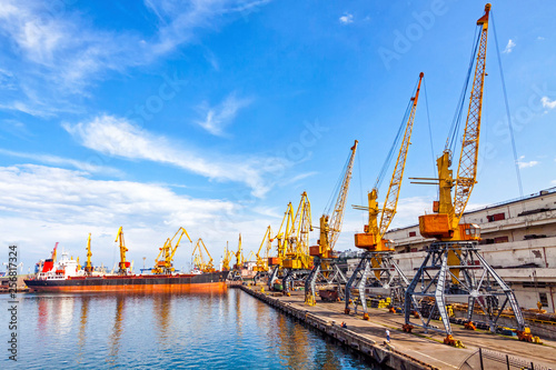 Lifting cargo cranes, ship and grain dryer in Sea Port of Odessa, Black Sea, Ukraine. Odessa Marine Trade Port is the largest Ukrainian seaport and one of the largest ports in the Black Sea basin