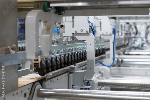 Man Inserting Carton into the Cart Paper Folding Machine Transfer Wheels Rollers Print Production